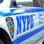 NYPD CRUSHED — 100-Car Gang TAKES OVER… Close-up of a NYPD police car.