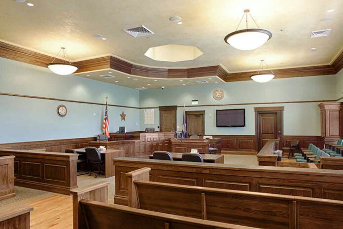 1349439551 Empty courtroom with wooden benches and desks.