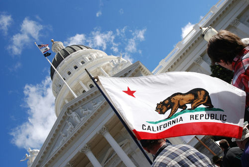 shutterstock642199051-1jpg California state flag waving near a white domed capitol building