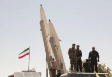 Iran “Lifeline” Fury—General Slams Trump Plan Soldiers stand beside large missiles at an outdoor display