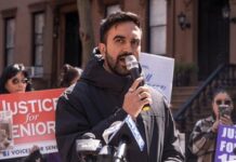 Hamas Sniper Or Journalist? Outrage Explodes Man speaking into a microphone at an outdoor rally