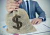 Person holding burlap bag with dollar sign.