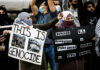 Protesters holding signs at a rally
