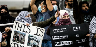 Protesters holding signs at a rally