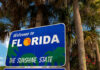 Welcome to Florida sign with palm trees background.