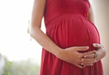 Surrogacy Standoff Explodes In Florida Pregnant woman in a red dress holding her belly