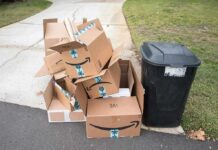 Package Horror Strikes Suburb Pile of flattened cardboard boxes beside a black trash bin
