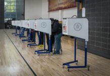 Proof-of-Citizenship Bombshell Looms Voters at polling booths in a gymnasium