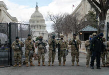 Armed soldiers standing guard outside the Capitol building