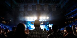 Audience at a concert with a person in a cowboy hat in the foreground