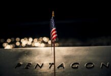 Missile Magazines Run Dry Close-up of a small American flag on a reflective surface with the word PENTAGON in the background