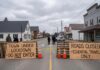 Barricades indicating a town lockdown with signs stating 'Do Not Enter' and 'Essential Travel Only'