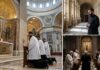 Clergy members kneeling in prayer inside a grand cathedral