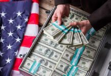 Hands holding bundles of US $100 bills over a briefcase of cash