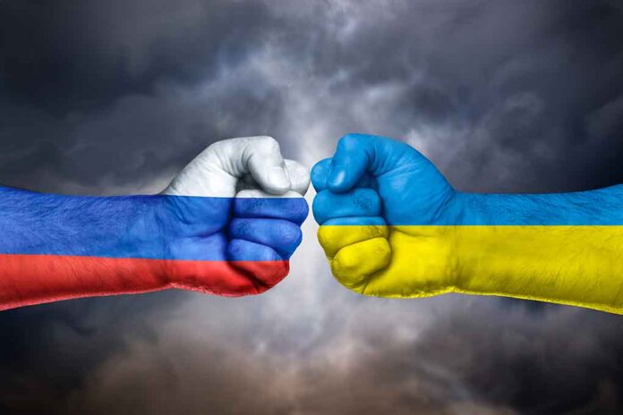 Fists painted in Russian and Ukrainian flags facing off.