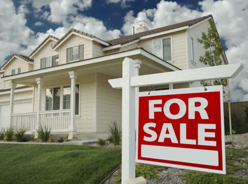 House with For Sale sign in front yard.