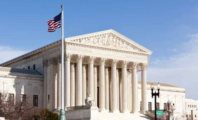 United States Supreme Court building with American flag.