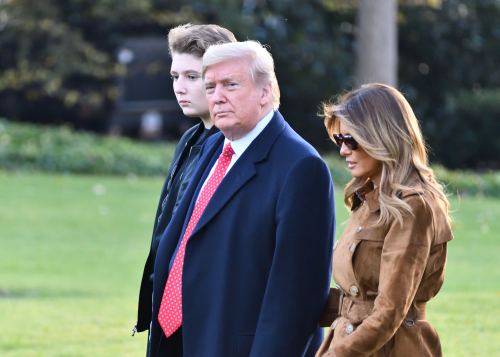 Donald Trump, Melania Trump, and Barron Trump walking outside.