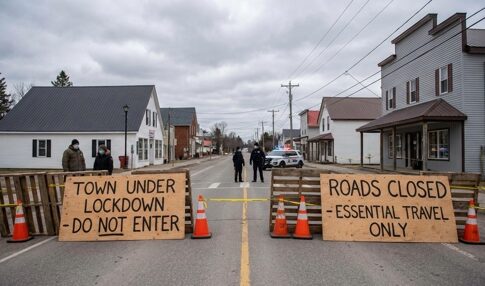 Barricades indicating a town lockdown with signs stating 'Do Not Enter' and 'Essential Travel Only'